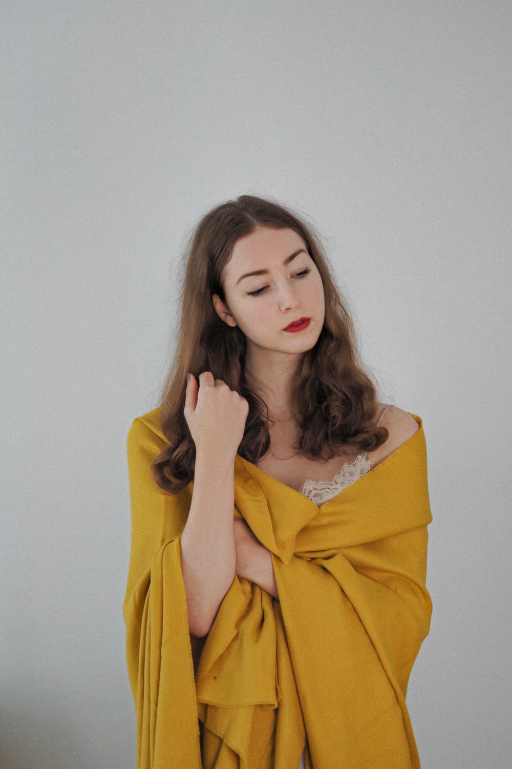 a woman wearing a yellow shawl with her hands on her chest