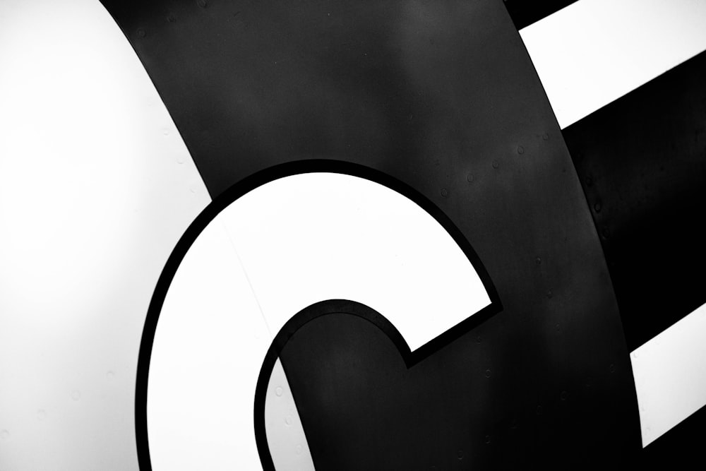 a close up of a black and white sign with the letter g