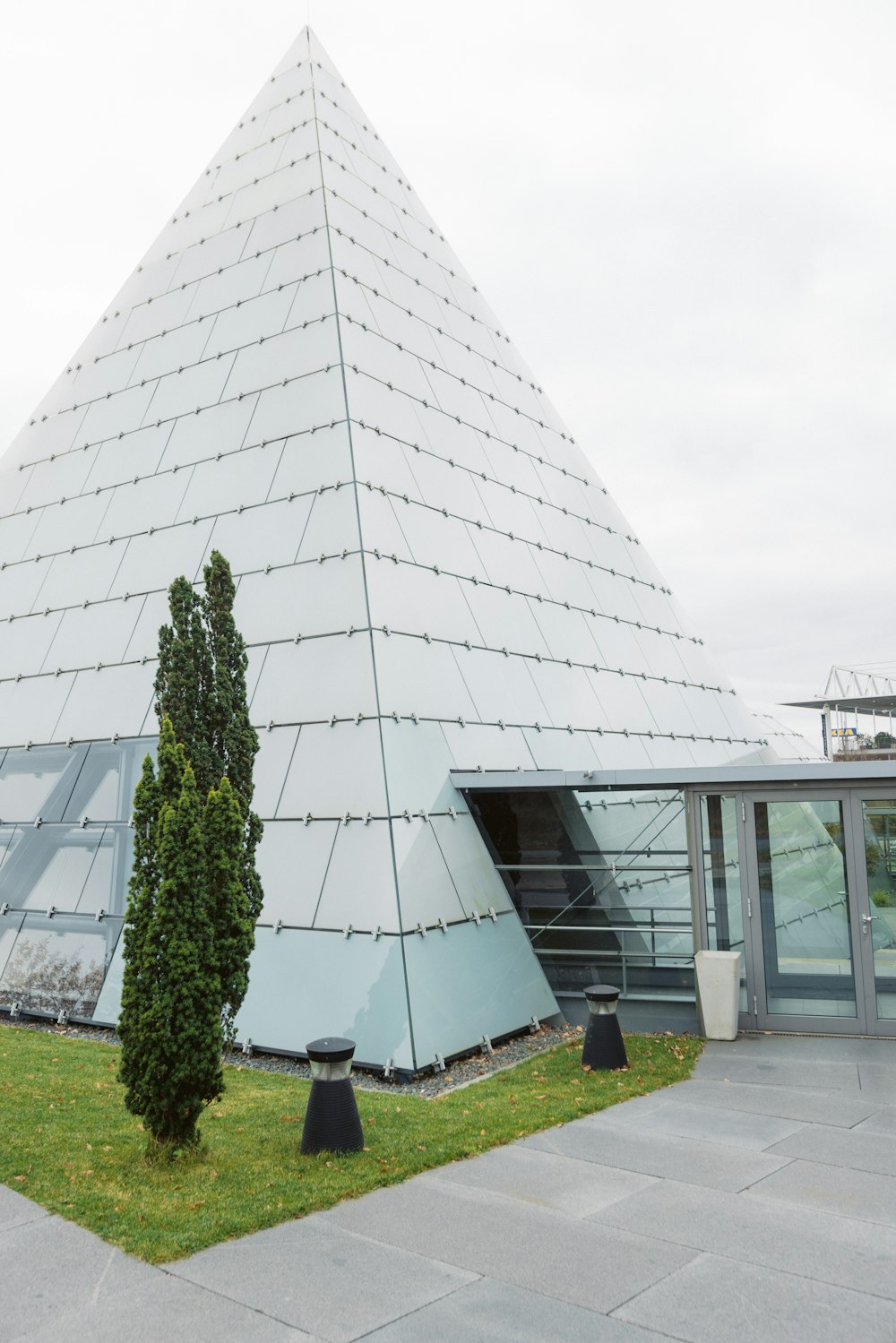 a large triangular building with a tree in front of it