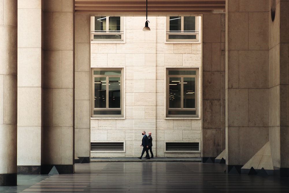 a man in a suit is walking through a building