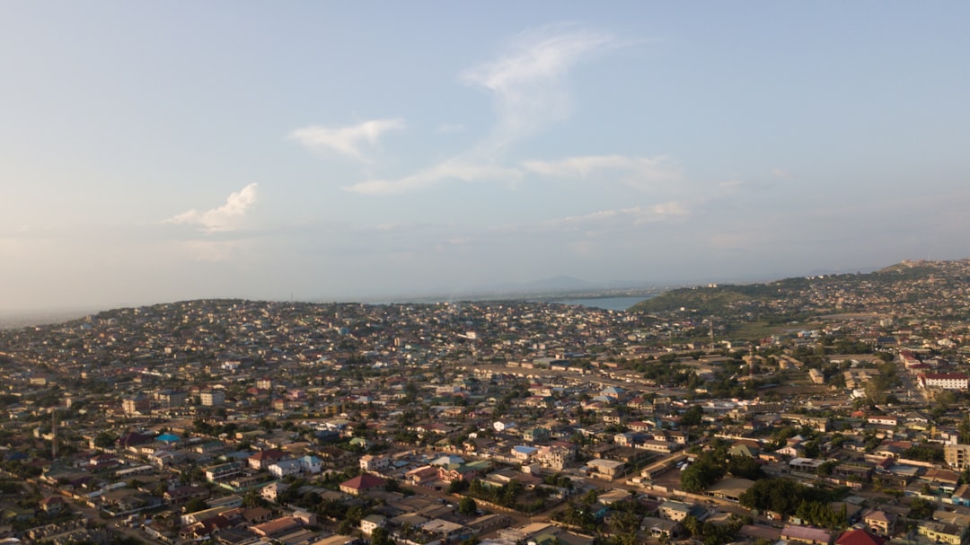 an aerial view of a city with a lake in the distance, Houses on the Horizon