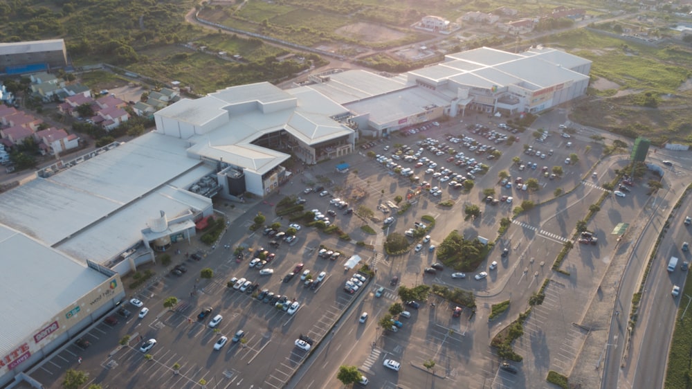 an aerial view of a parking lot with a large building in the background