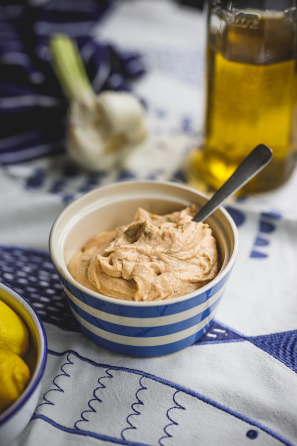 A bowl of hummus next to a bowl of lemons