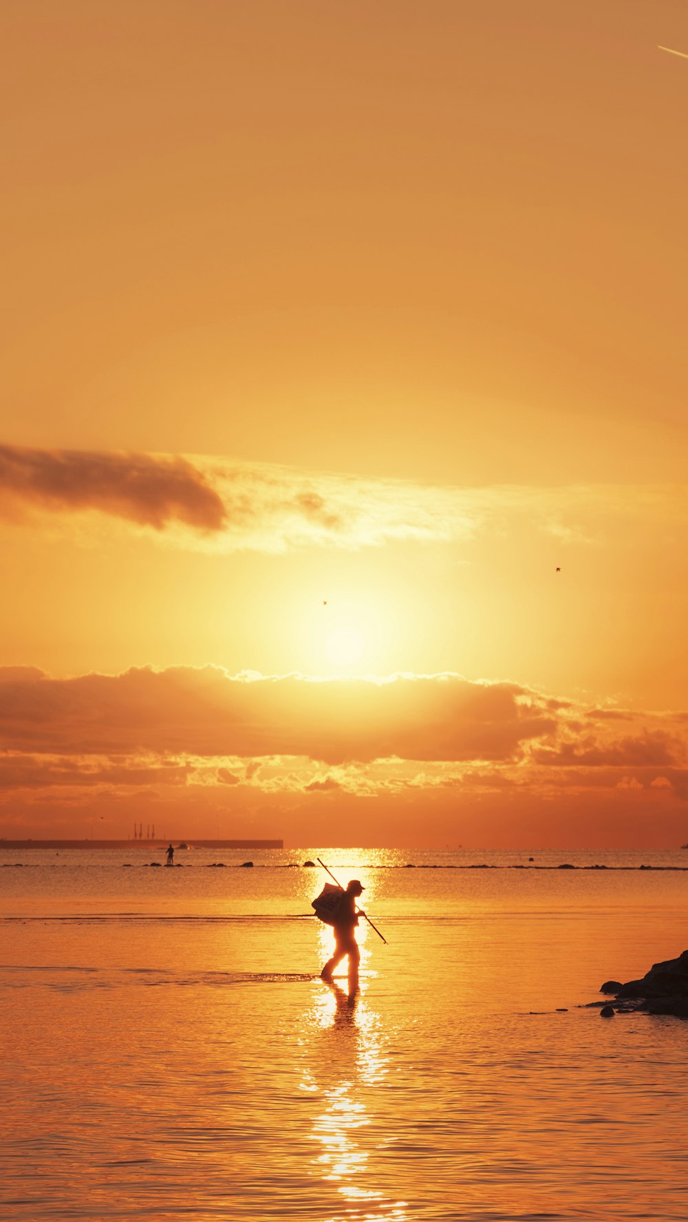 uma pessoa em uma prancha de surf na água ao pôr do sol