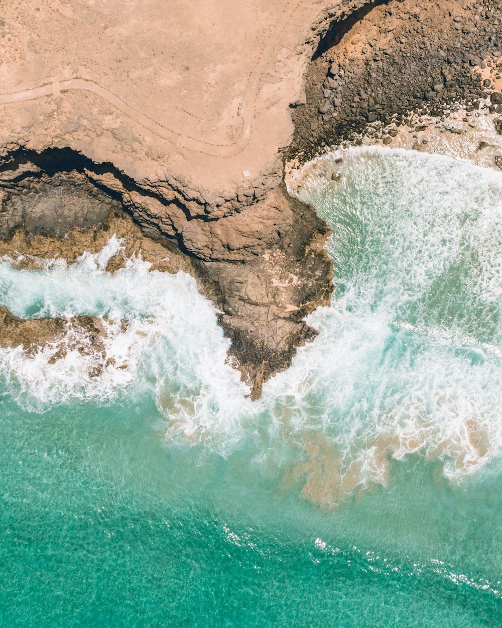 a bird's eye view of the ocean and rocks