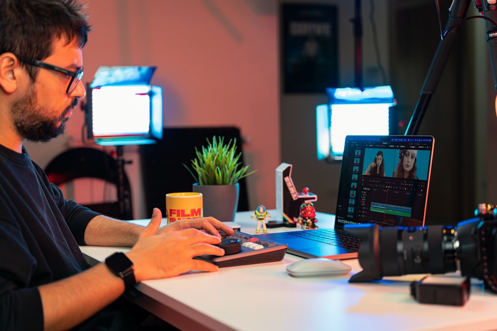 a man sitting at a desk using a laptop computer