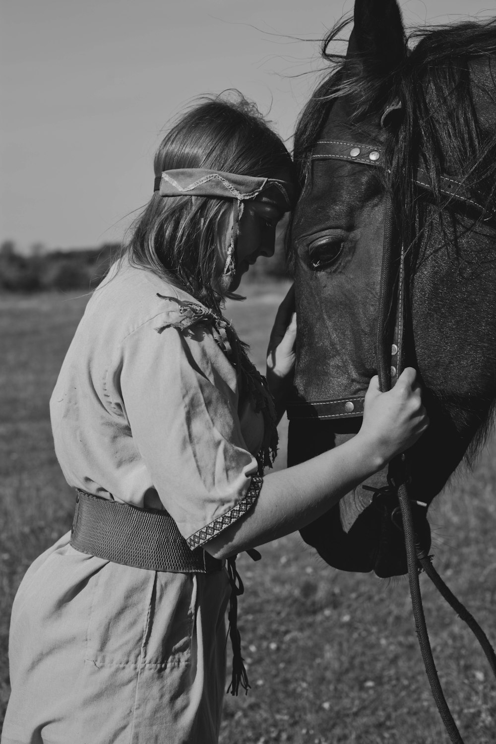 a woman is petting a horse in a field
