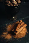 a bowl of nuts and cinnamon sticks on a table