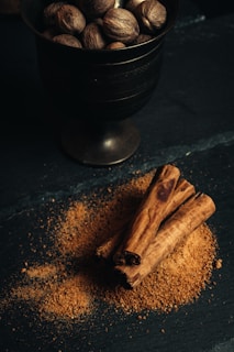 a bowl of nuts and cinnamon sticks on a table