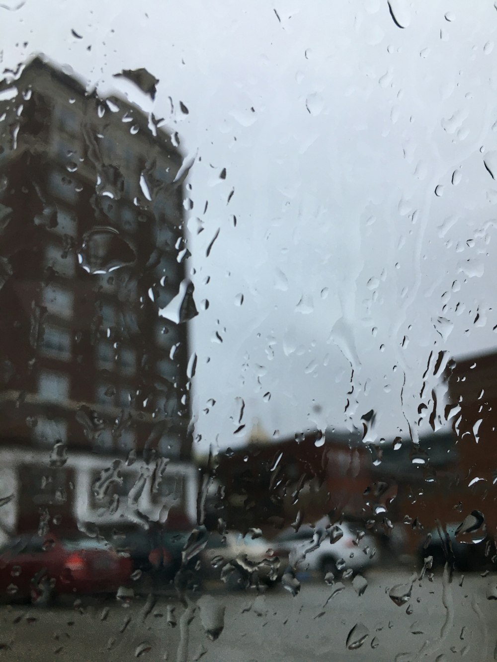 a view of a building through a rain covered window