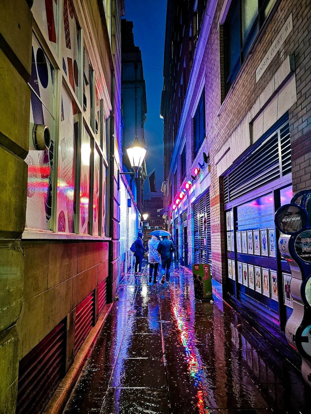 a group of people walking down a street at night