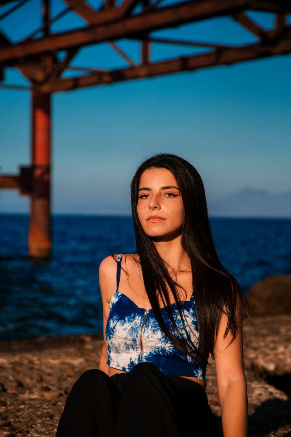 Eine Frau sitzt an einem Strand am Meer