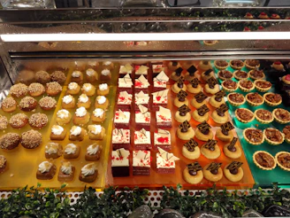 A colorful display of assorted pastries and desserts arranged invitingly on a rustic wooden table.