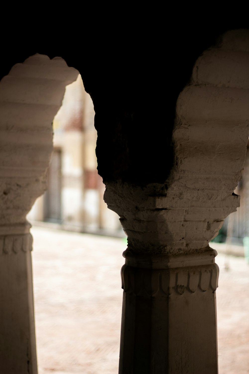 a black and white cat sitting on top of a stone pillar