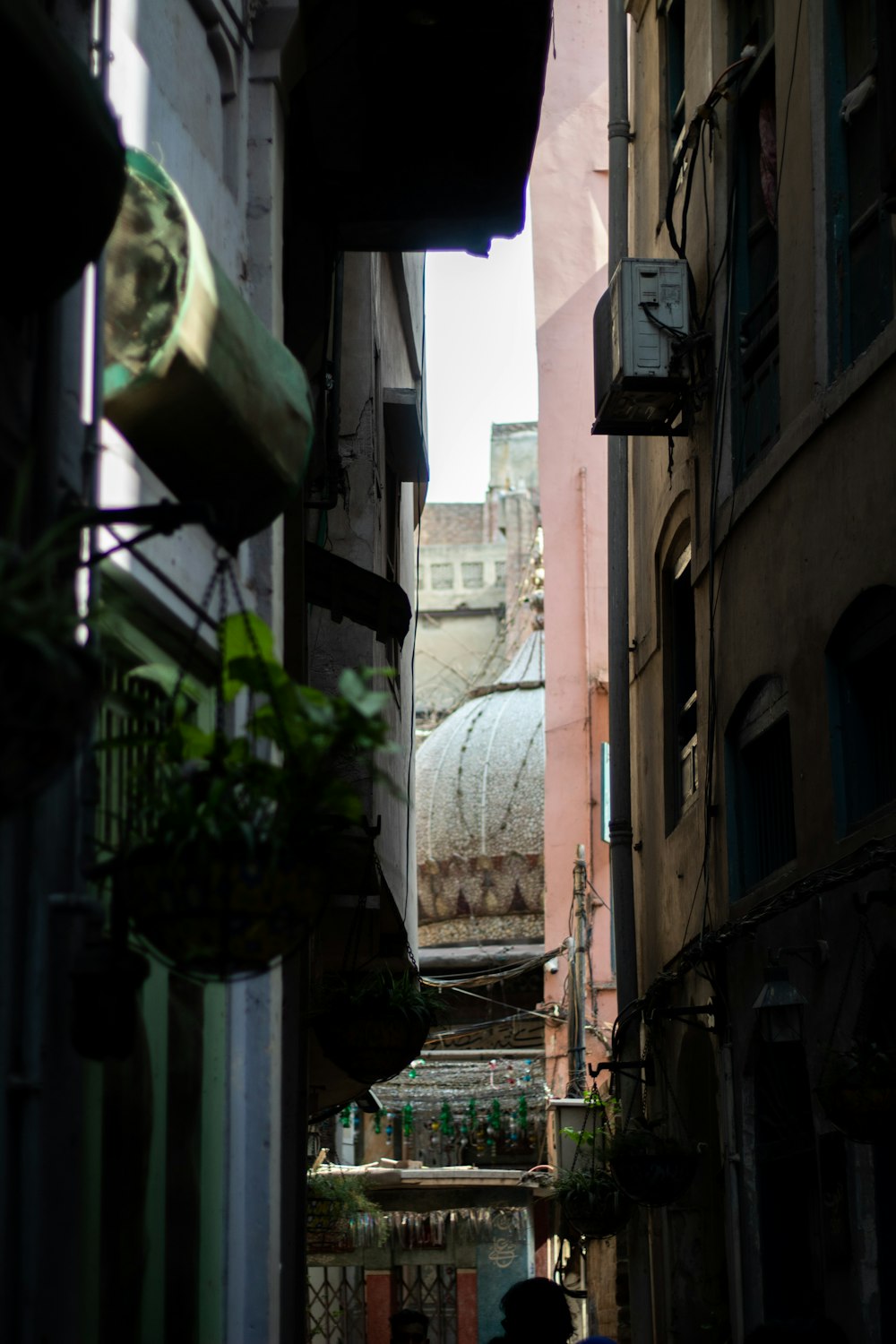 a narrow alley way with a person walking down it