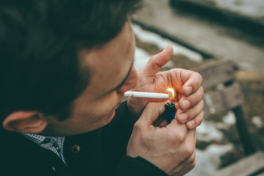 a man smoking a cigarette in a park