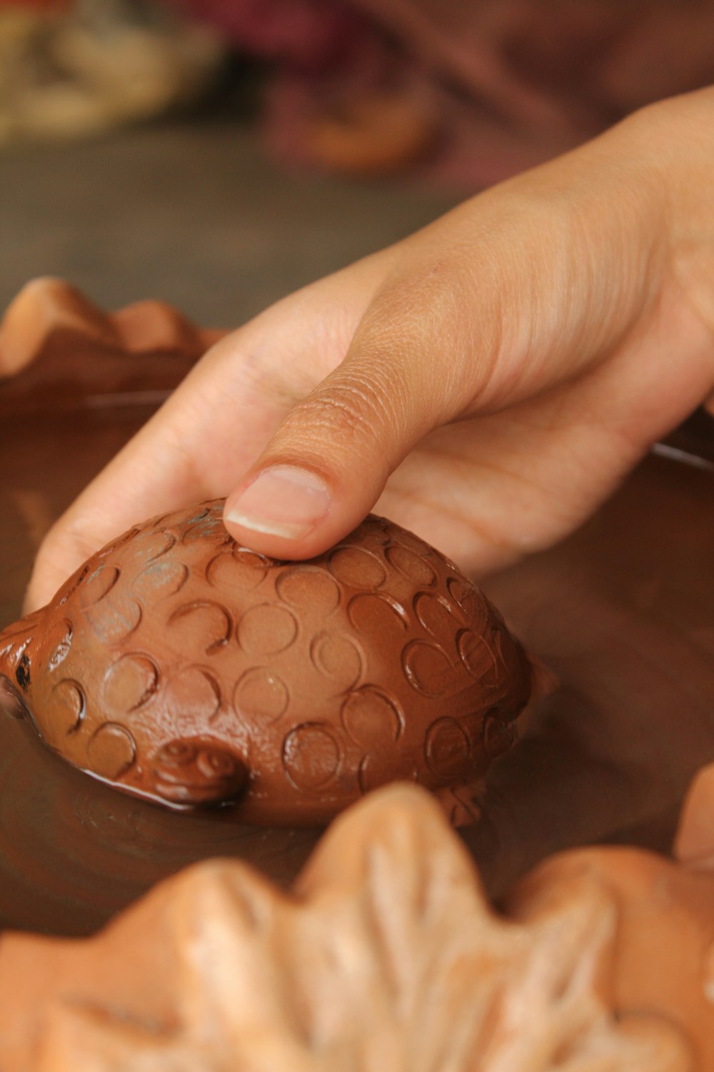 a hand touching a chocolate object on a table