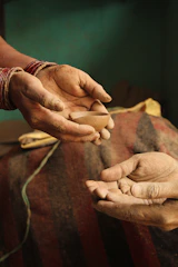 a pair of hands holding a piece of wood
