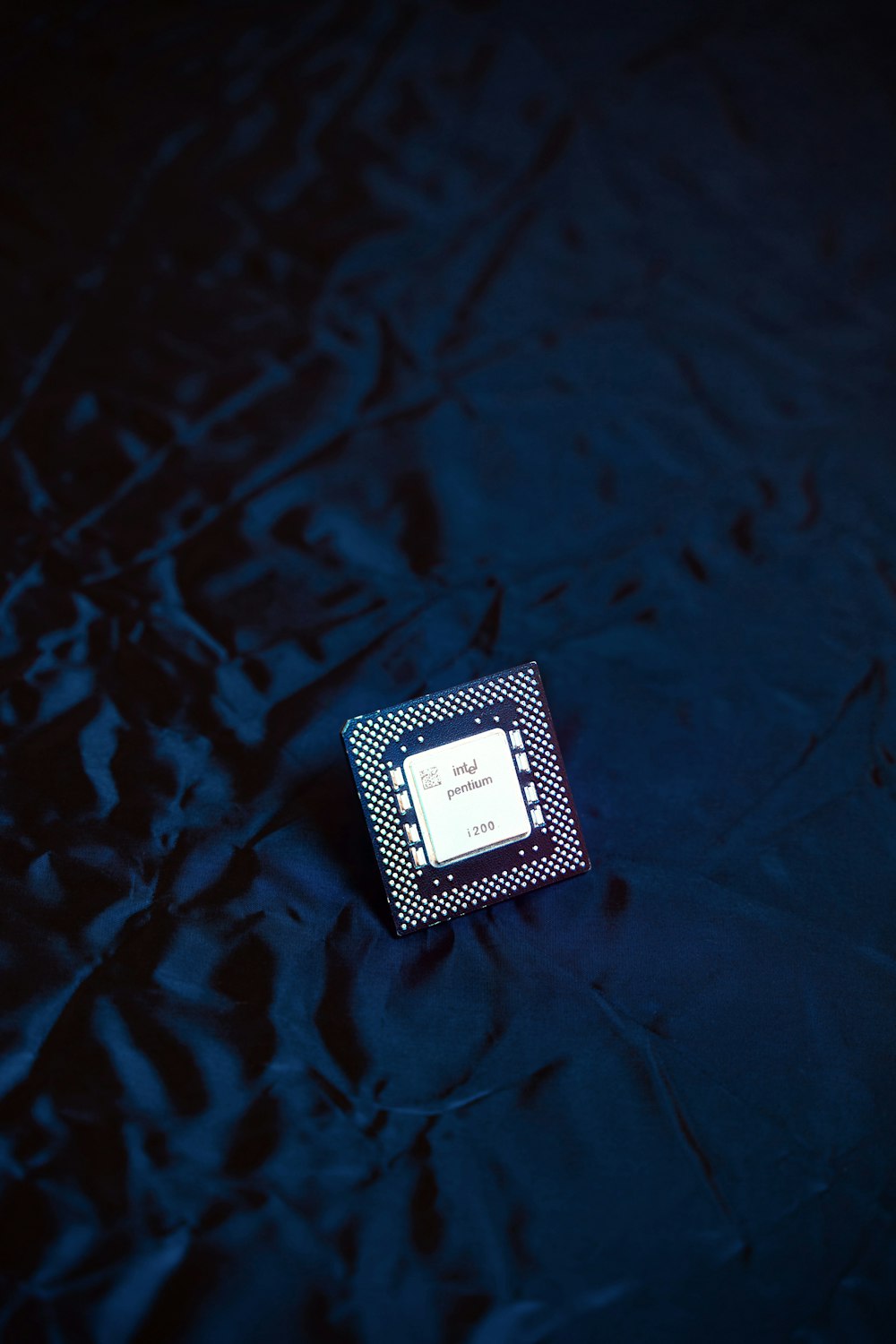 a small square object sitting on a blue cloth