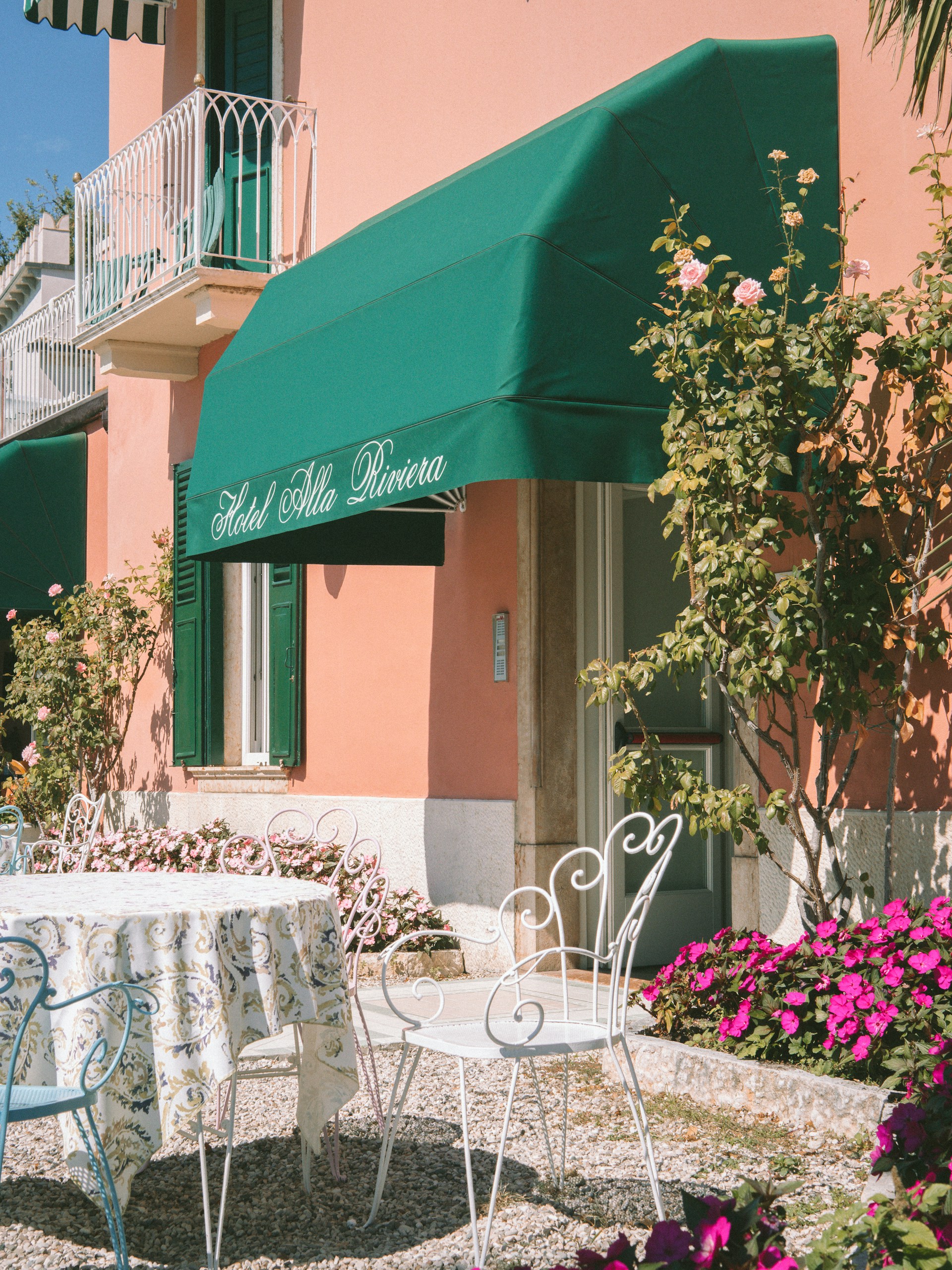 a table and chairs outside of a pink building