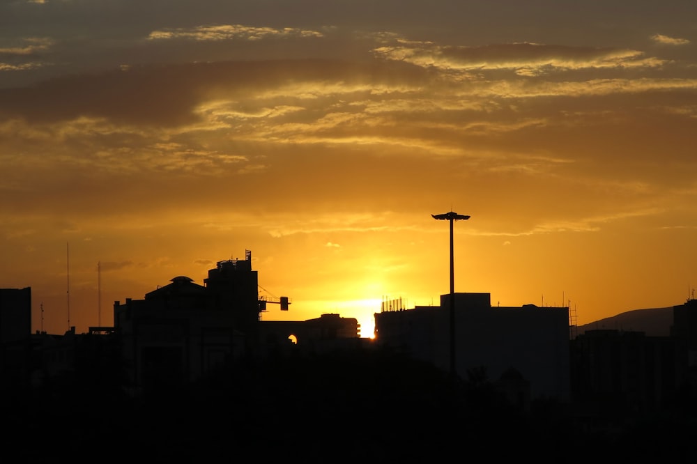 the sun is setting over a city with tall buildings