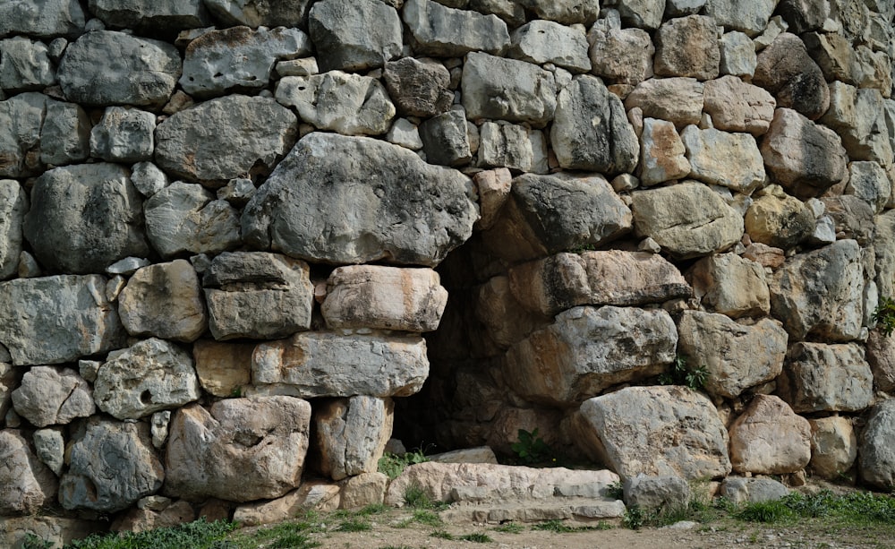 a stone wall made of rocks and grass