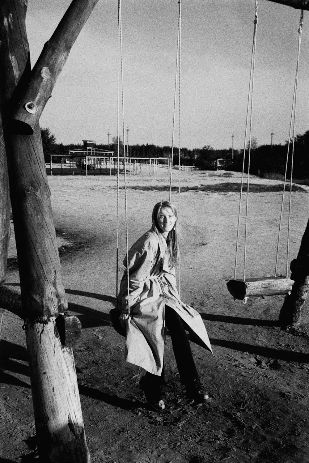 a woman sitting on a swing in a park