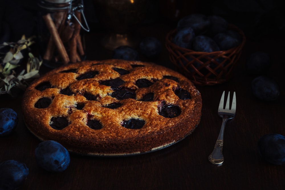 a blueberry pie on a table with a fork
