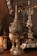 Intricate silver goblets and ornate metalware with detailed engravings and a reflective surface are displayed. The objects have a rich patina, suggesting age and craftsmanship.