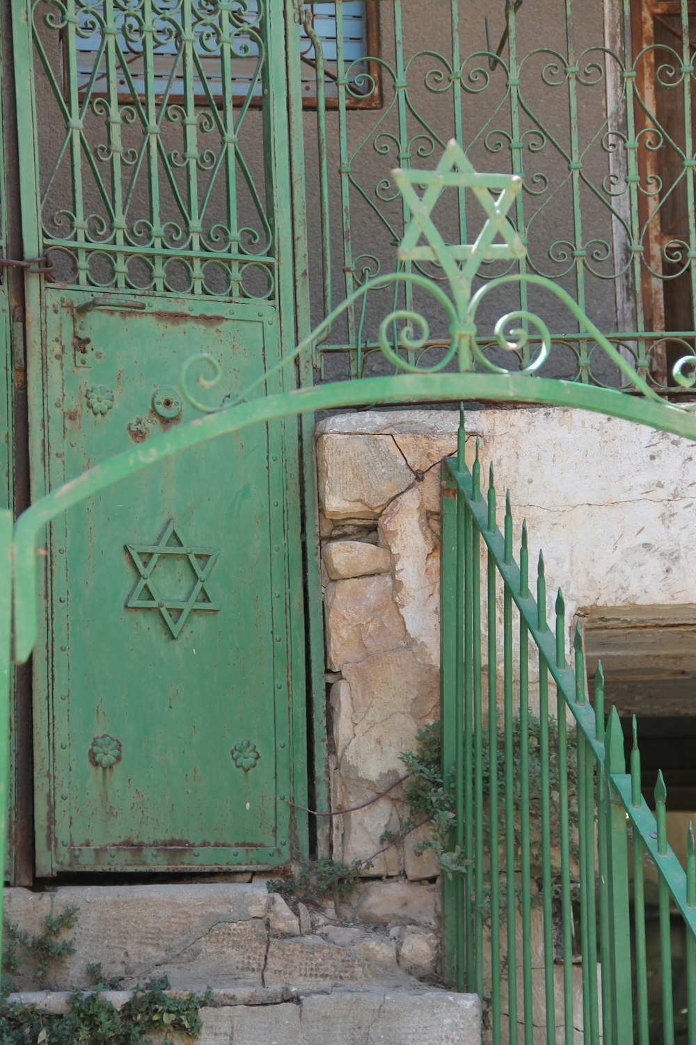 a green gate with a star of david on it