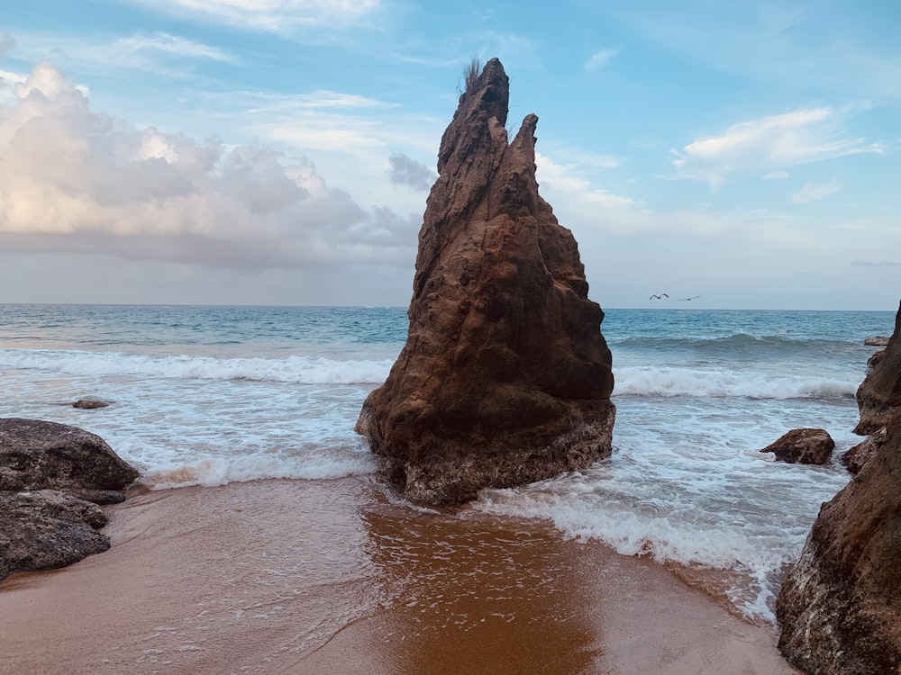 a large rock sticking out of the ocean