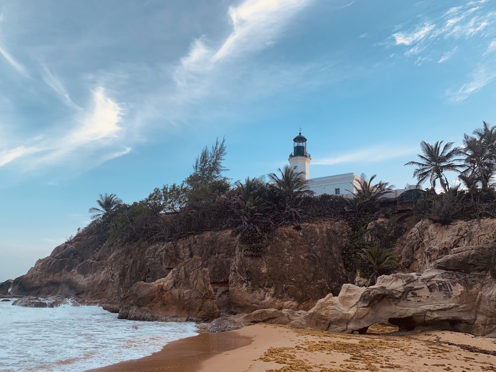 a lighthouse on top of a cliff next to the ocean