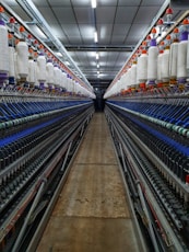 a large room with rows of machines and spools of thread