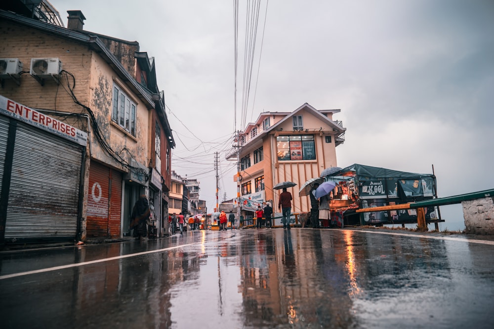 a group of people walking down a street in the rain