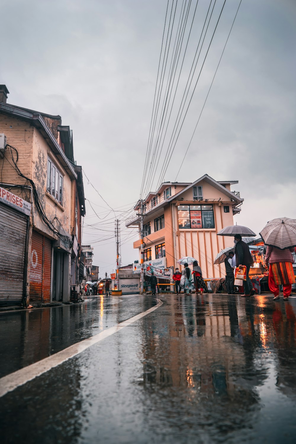 a group of people walking down a street holding umbrellas