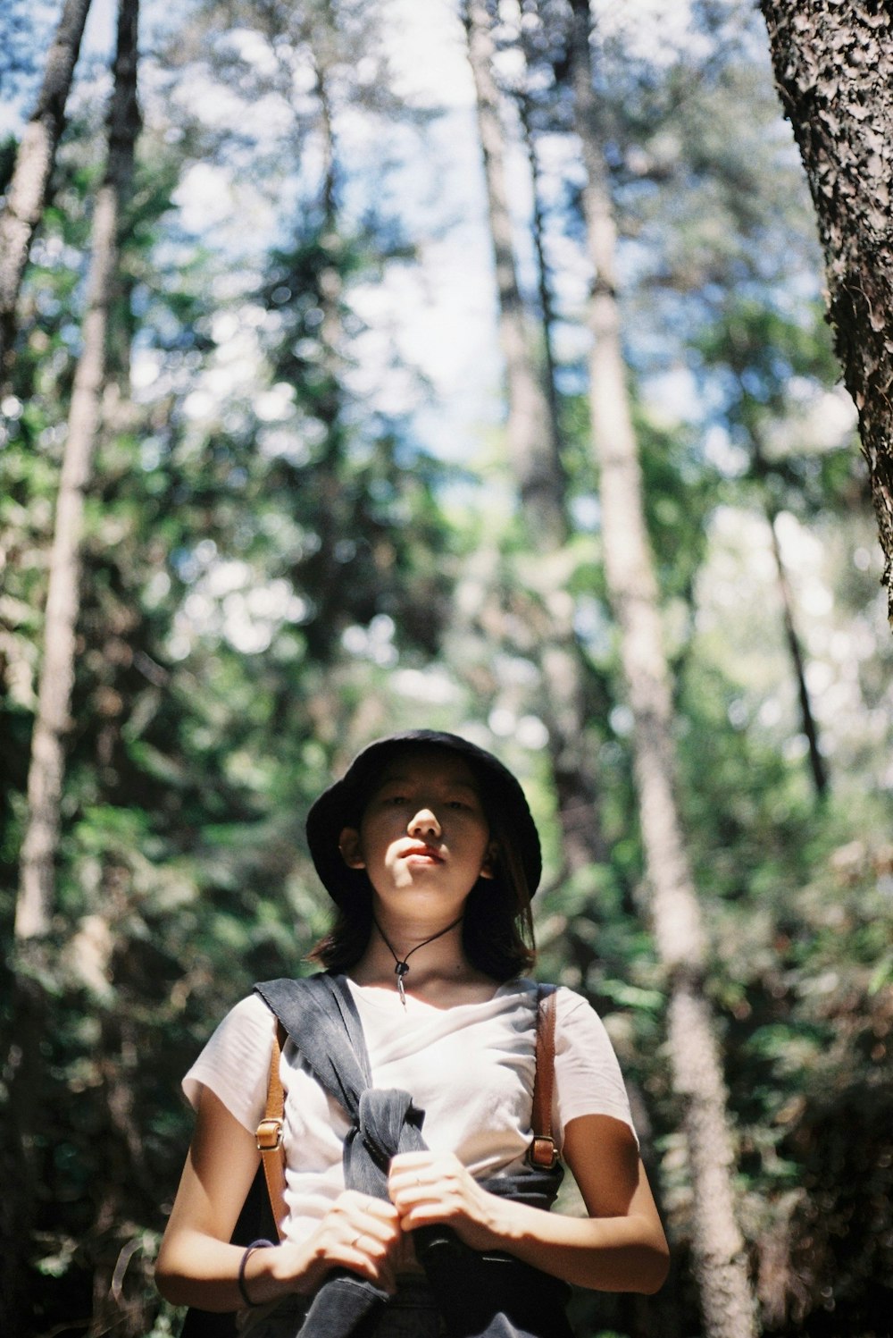 a woman standing in the middle of a forest