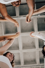 a group of people standing in a circle holding hands