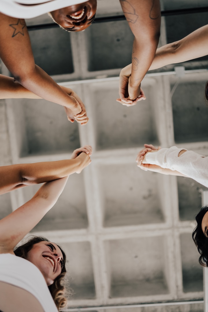 a group of people holding hands in pairs while they participate in trauma informed disability training