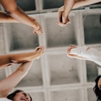 a group of people standing in a circle holding hands