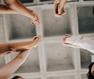 a group of people standing in a circle holding hands