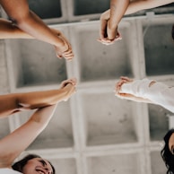 a group of people standing in a circle holding hands