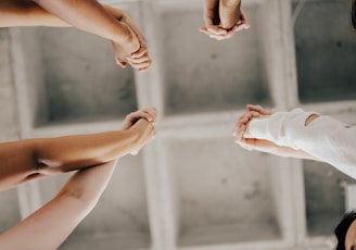 a group of people standing in a circle holding hands