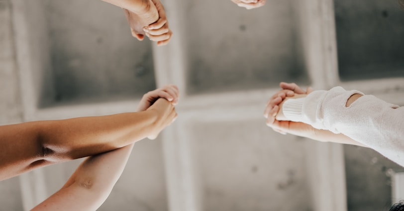 a group of people standing in a circle holding hands