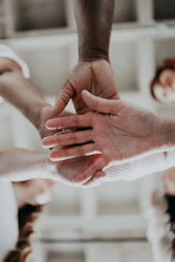Close-up of hands shaking over a blueprint of a solar project, symbolizing partnership.