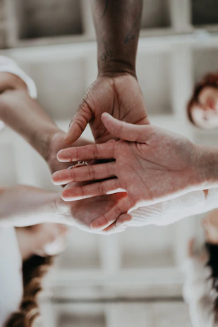 Close-up of hands shaking over a blueprint of a solar project, symbolizing partnership.