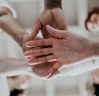 a group of people putting their hands together