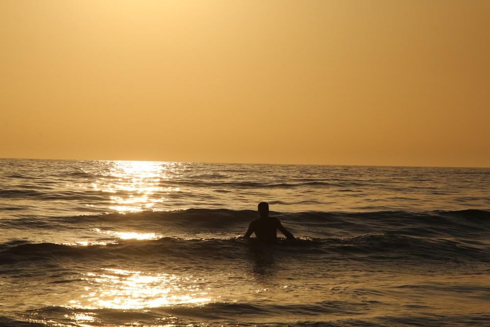 a person sitting on a surfboard in the ocean