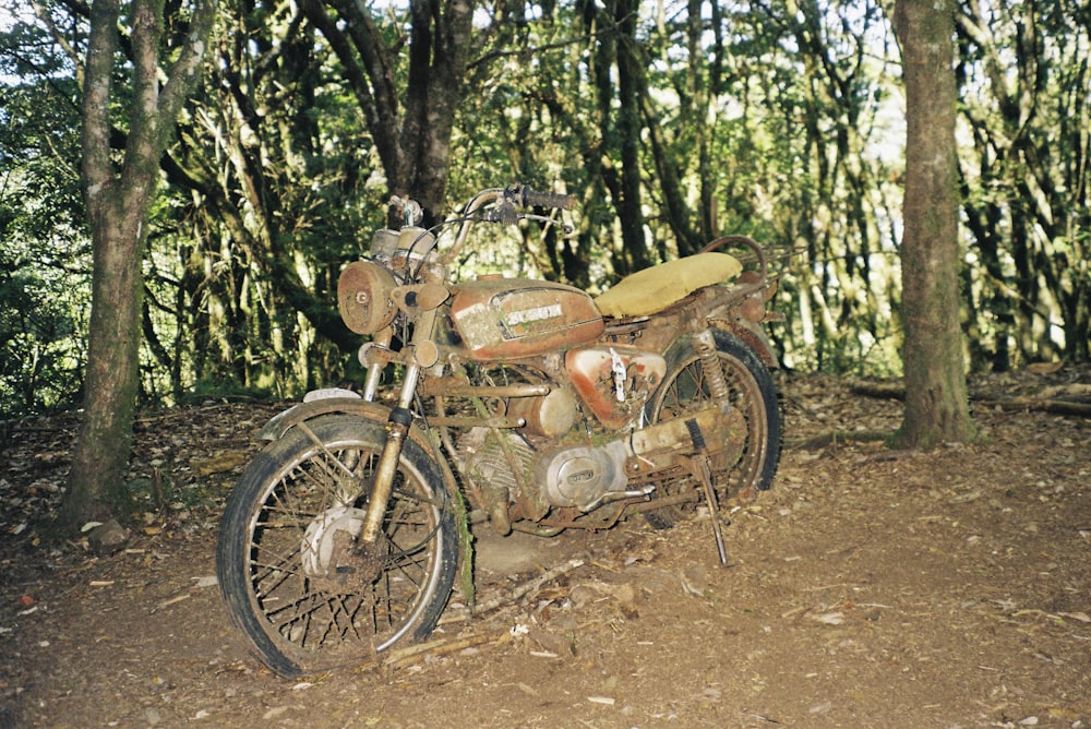 an old motorcycle is parked in the woods