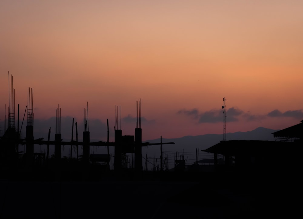 a silhouette of a building with a sunset in the background