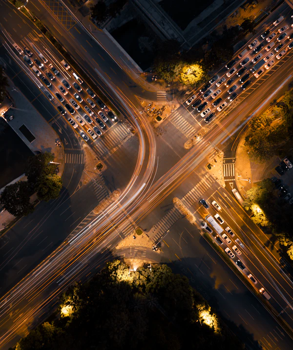 High-altitude aerial view of a 4-way signalized road intersection at night